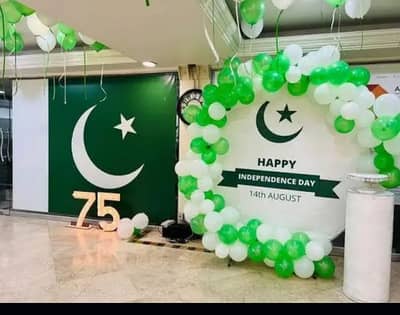 14 August Pakistan Independence Day office backdrop decor in Lahore with round balloon arch, Pakistan flag, and illuminated 75 number for corporate celebration.