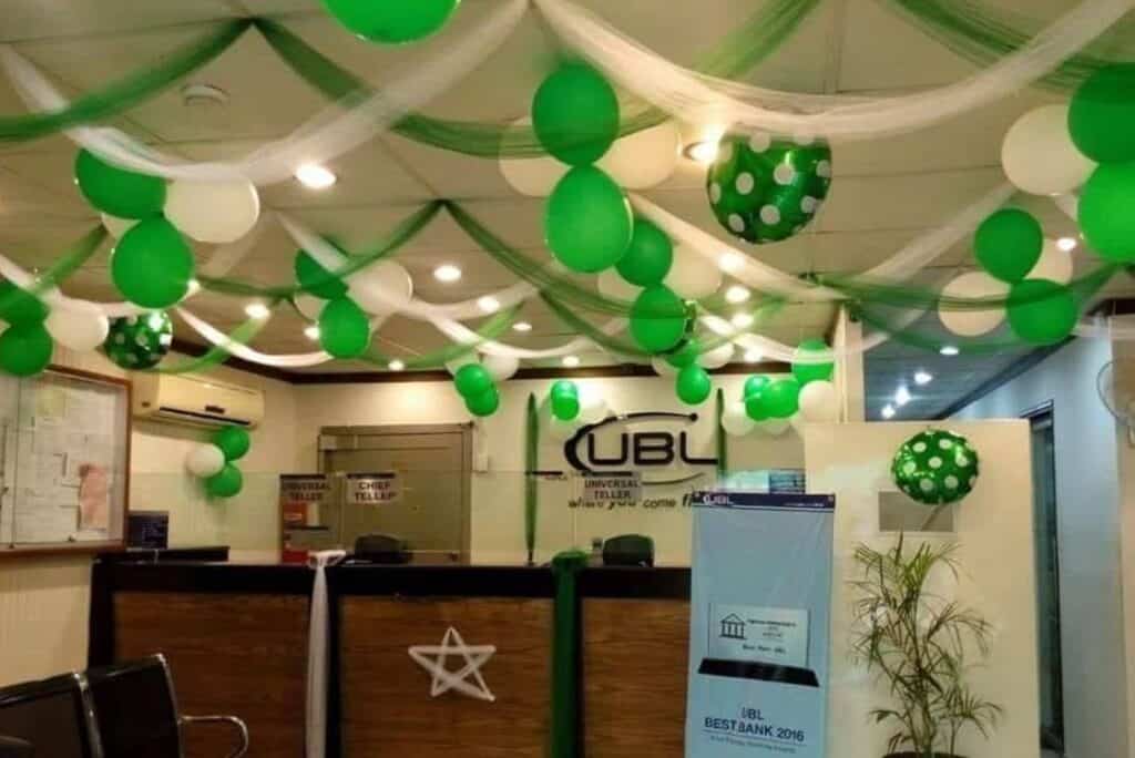 14 August corporate office decoration setup with green and white balloons, ceiling drapes, and a professional patriotic theme.