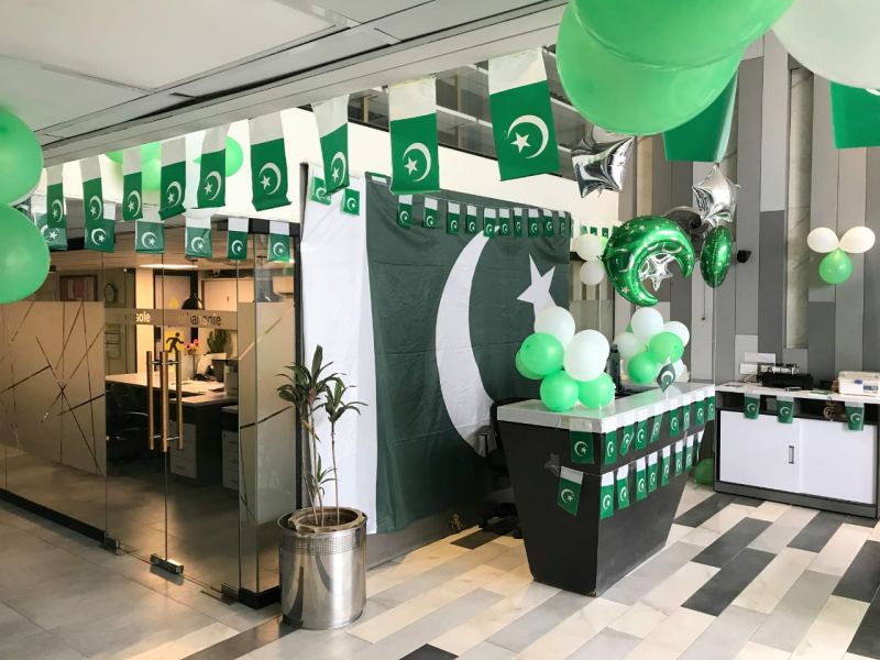 14 August reception area decoration with Pakistan flags, green and white balloons, and patriotic theme setup for corporate offices and workplaces in Pakistan.