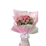 A beautiful hand-held bouquet featuring fresh cream-yellow roses and white baby's breath wrapped in decorative white butterfly paper with a pink ribbon.