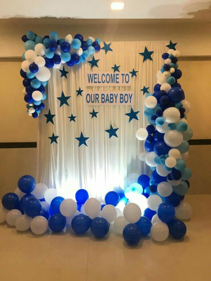 Baby crib decorated with blue and white balloons for baby shower celebration.