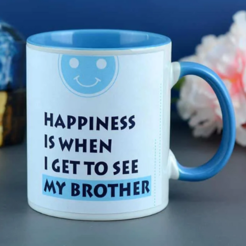Blue ceramic mug with quote: “Happiness is when I get to see my brother” and smiley icon