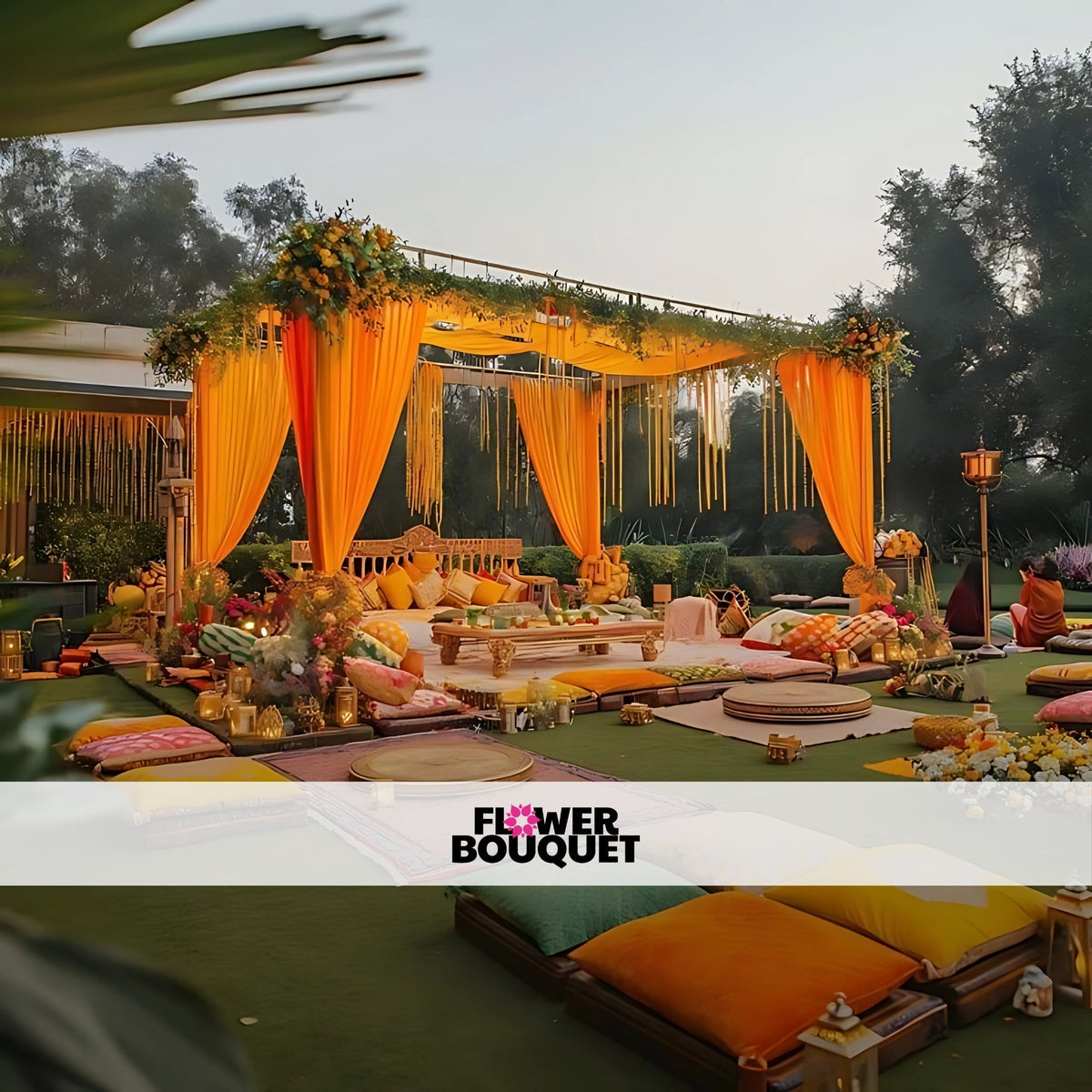 Outdoor Mehndi pavilion with yellow and orange drapes, floral accents, cozy floor seating, and traditional low tables for a grand celebration.