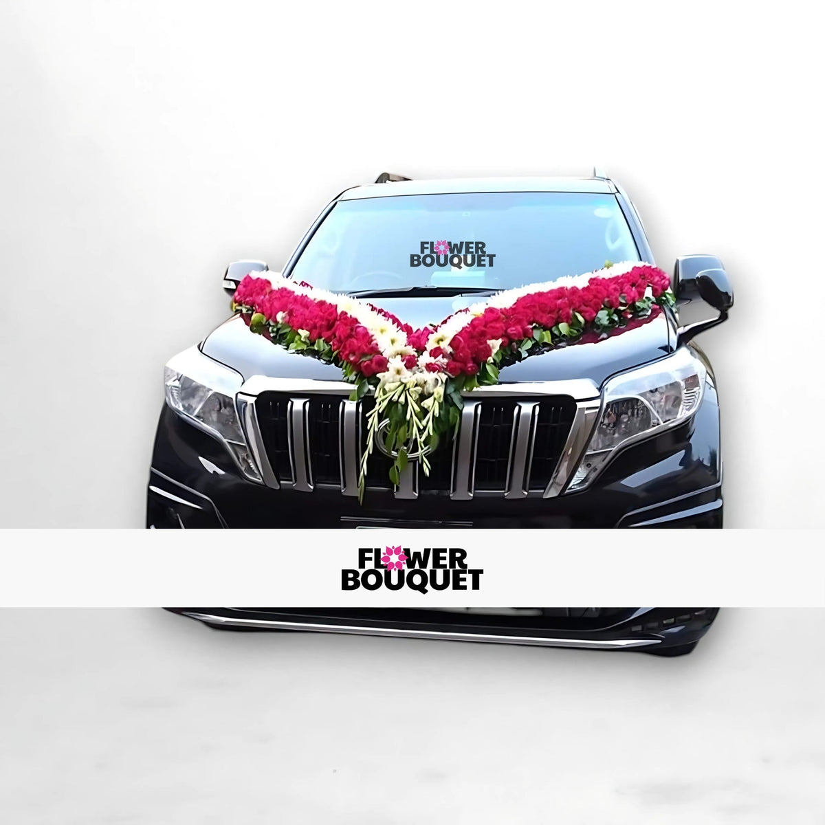 Black car decorated with red and white flowers in a V-shape on the hood.