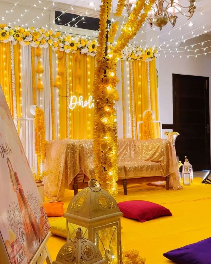 A beautifully decorated Mayo setup with yellow flowers, string lights, cushions, and lanterns, creating an elegant and festive atmosphere for a pre-wedding event.