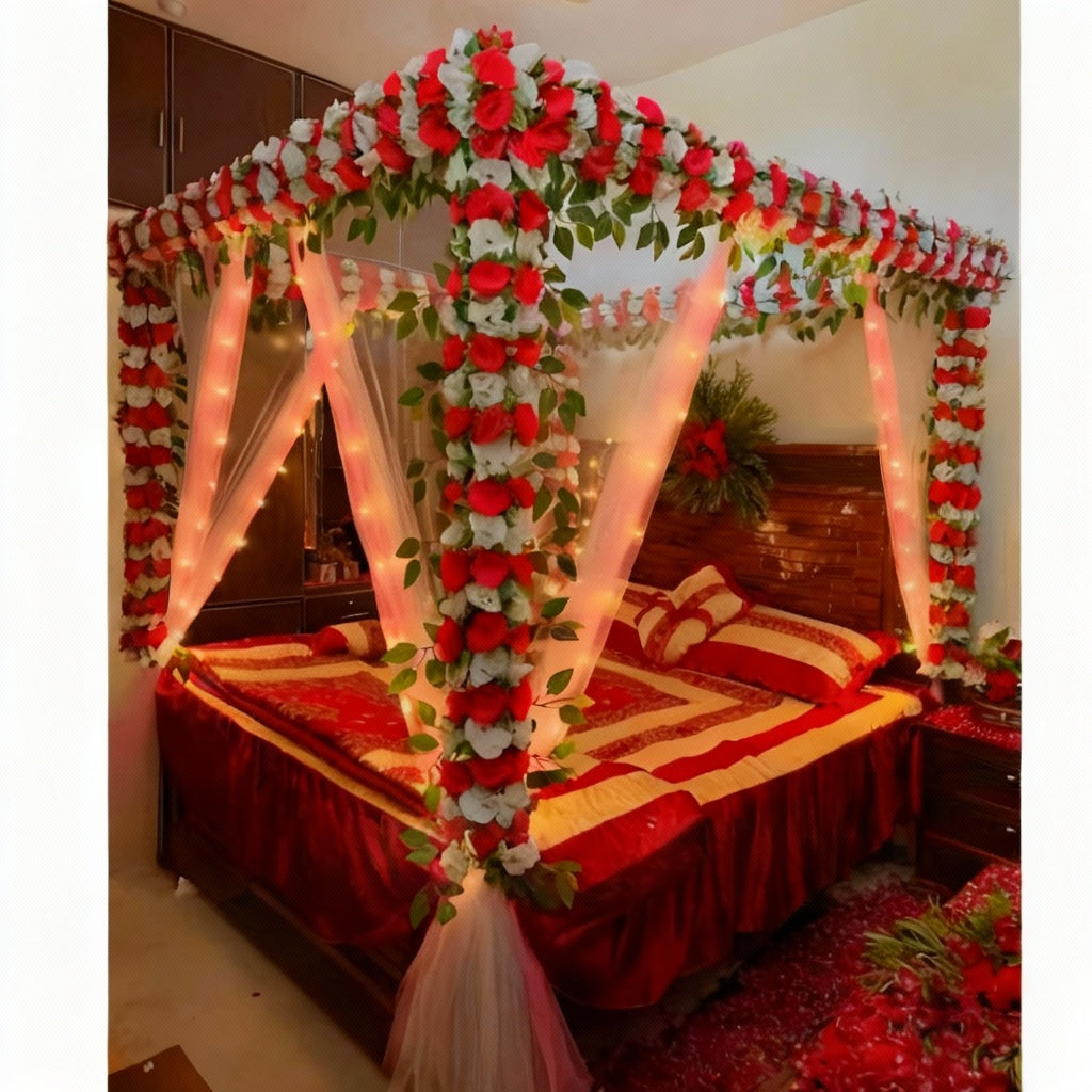 Enchanted Floral Canopy Bed Decor with red and white flowers, green foliage, string lights, and white fabric drapery.