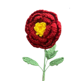 Handmade crochet marigold-inspired flower with red petals, yellow center, and green leaves.