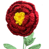 Handmade crochet marigold-inspired flower with red petals, yellow center, and green leaves.