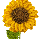 Handmade crochet sunflower with yellow petals, brown center, and green leaf on a stem.