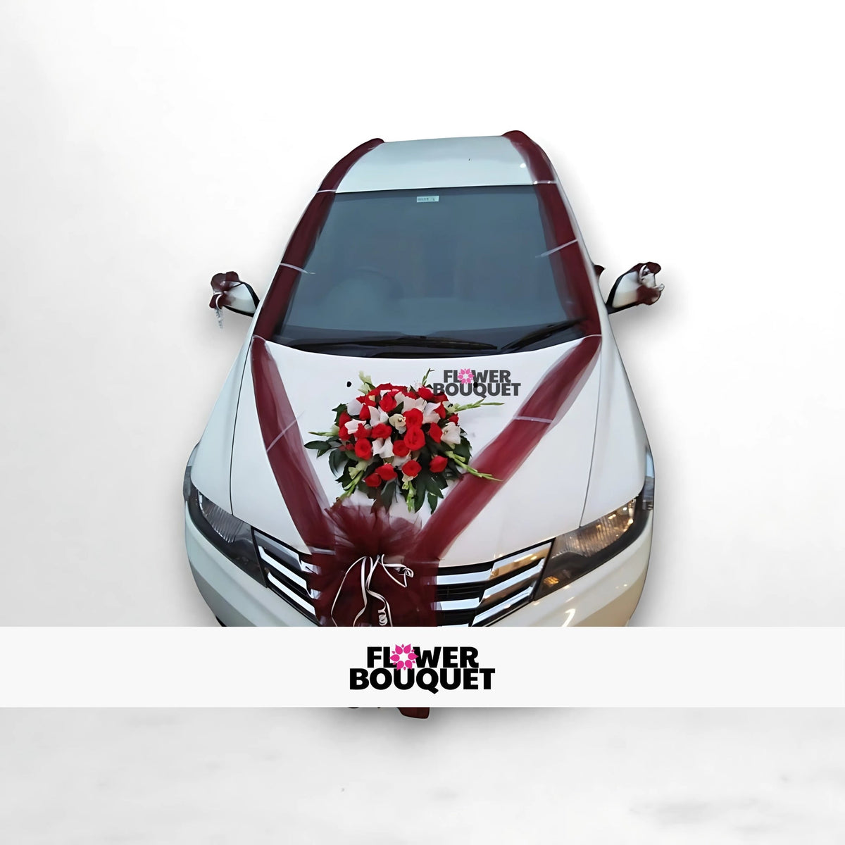 White car decorated with maroon ribbons and a floral arrangement on the hood.