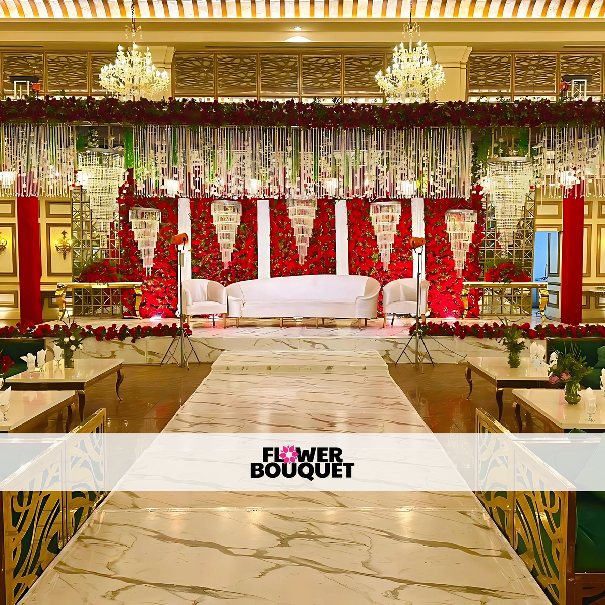 Luxurious Walima stage featuring a red rose floral wall, crystal chandeliers, white tufted sofa, and a marble-textured walkway, perfect for elegant celebrations.