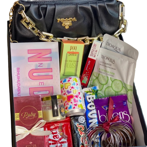 Luxury glam gift box with handbag, Huda Beauty nude palette, Pixi blush, lip gloss, Bioaqua sheet masks, Bonanza perfume, chocolates, bangles, scented candle, and fairy lights.