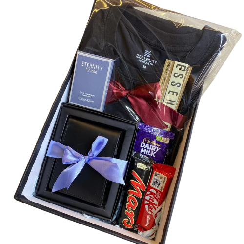 Luxury men’s gift box containing a Zellbury black t-shirt, Calvin Klein Eternity perfume, ESSEN chocolate, Dairy Milk, Mars, KitKat, and a premium leather wallet with ribbon.
