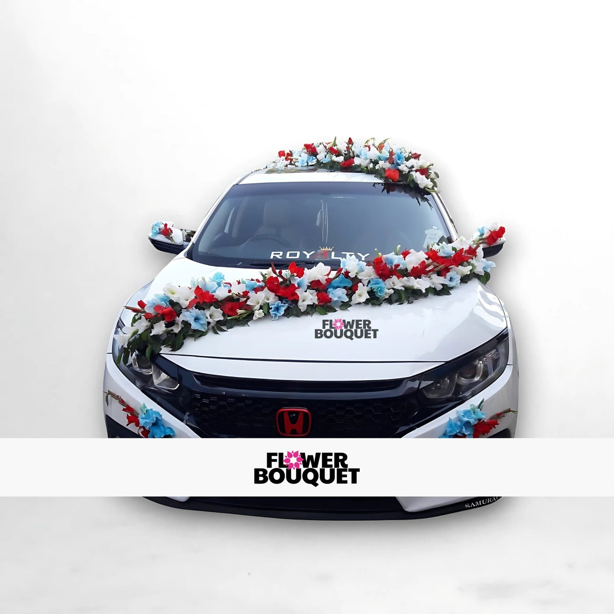 White Honda car decorated with a garland of red, white, and blue flowers.