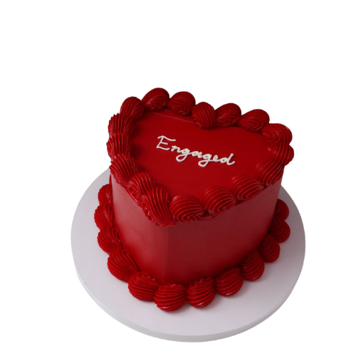 Red heart-shaped engagement cake with Engaged message and cream swirls.