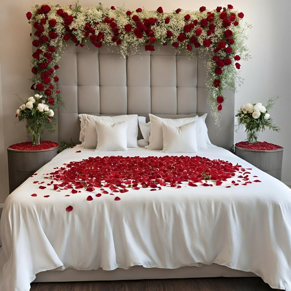 Romantic Rose Petal Bed Decor with white bed, heart-shaped red rose petals, and cascading floral canopy.