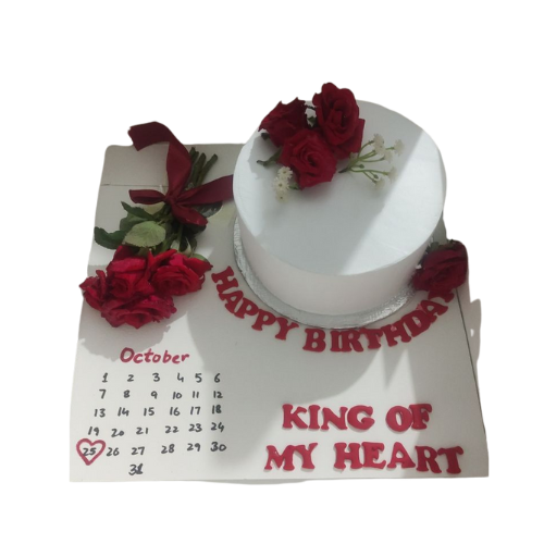Romantic white birthday cake decorated with fresh red roses and a calendar-style base with “Happy Birthday King of My Heart” text.