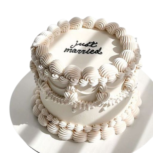 Two-tier white wedding cake with cream piping and “Just Married” message