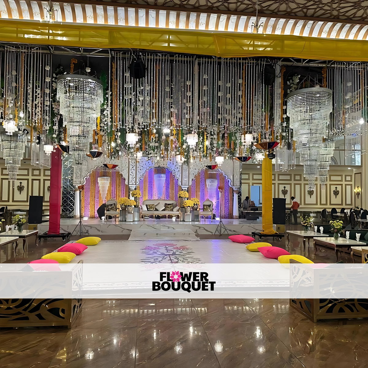 Wedding stage featuring cascading crystal chandeliers, vibrant floral accents, arched backdrop frames, and luxurious tufted seating, ideal for regal celebrations.