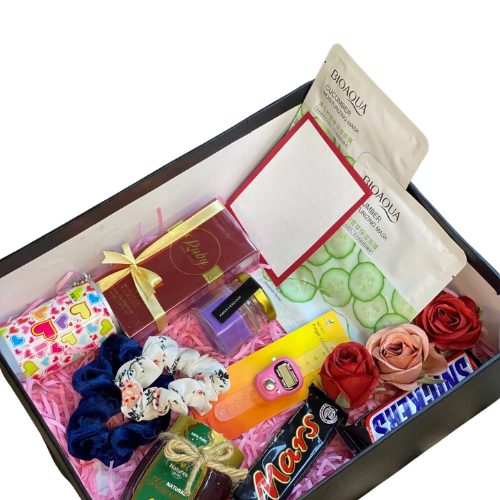 Wellness gift box with scented candle, Bioaqua sheet masks, Bonanza Ruby perfume, honey jar, chocolates, scrunchies, tasbih counter, and handwritten card.
