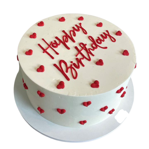White cream birthday cake decorated with red fondant hearts and “Happy Birthday” written on top in red icing.